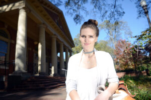 Sophie Wiseman-Floyd, sophomore studying Industrial Design, sits in front of Leazar Hall, which houses the studio and office space for the School of Design. Wiseman-Floyd is wearing a necklace of her own design from one of her two companies, Heir Raleigh. Wiseman-Floyd started her first company, Haiti's Jewels, in 2012 and founded Heir Raleigh in 2014.  