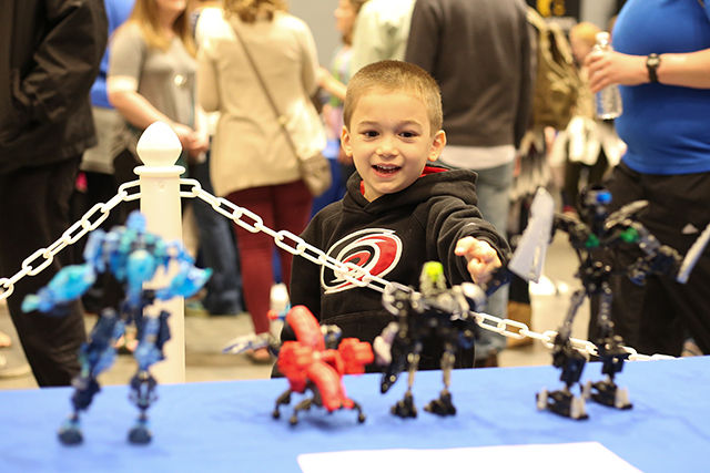 boy points at small robots