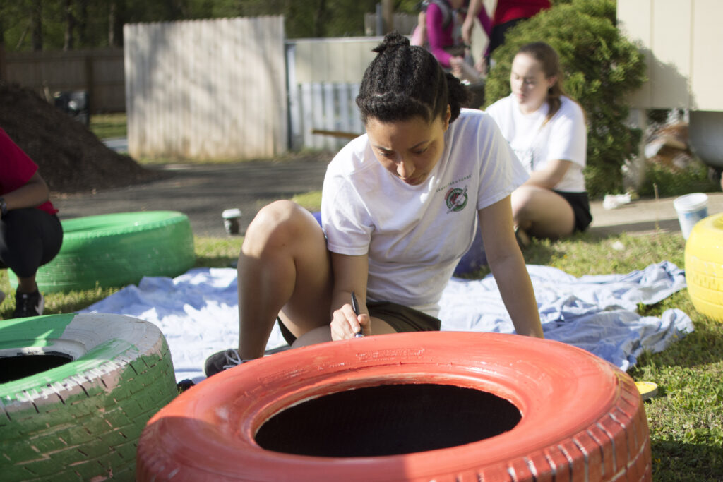 Kallyn Tall paints a tire for Service Raleigh