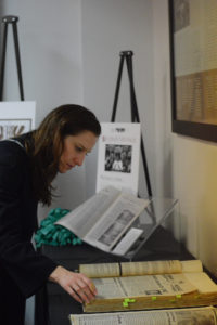 Woman bends over to read archive books.