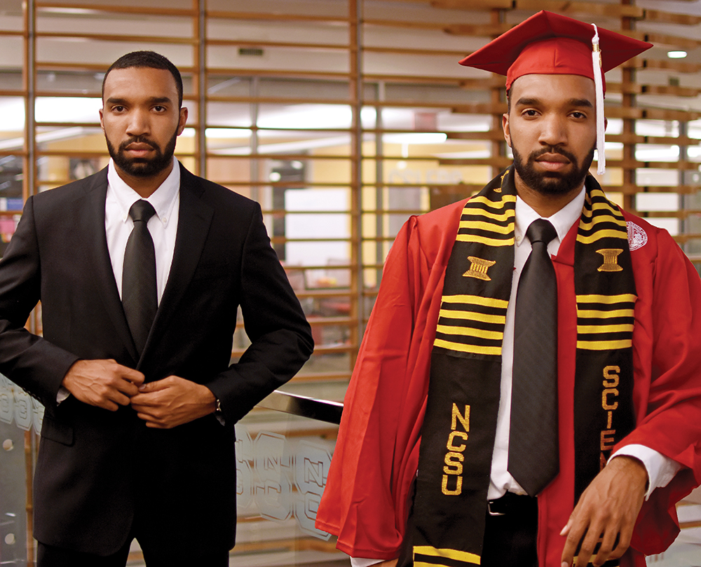 A man poses in a business suit and a graduation robe